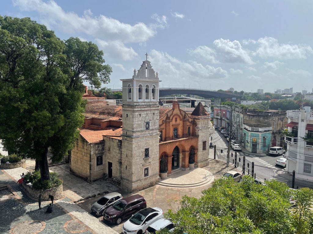 Aerial view of a historic colonial church in Santo Domingo under a bright day.