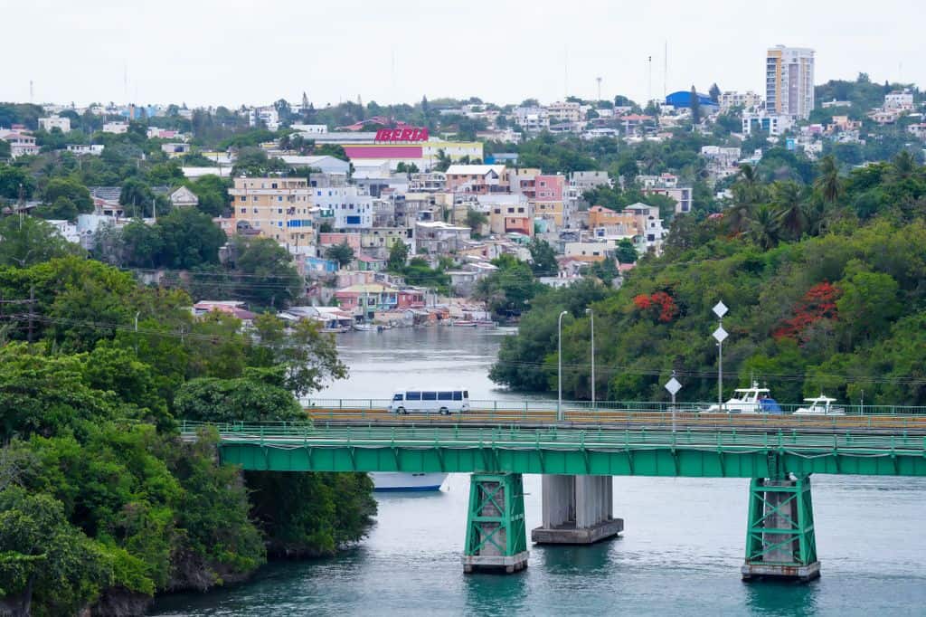 Colorful riverside townscape with bridge and lush greenery. Vibrant urban scenery.