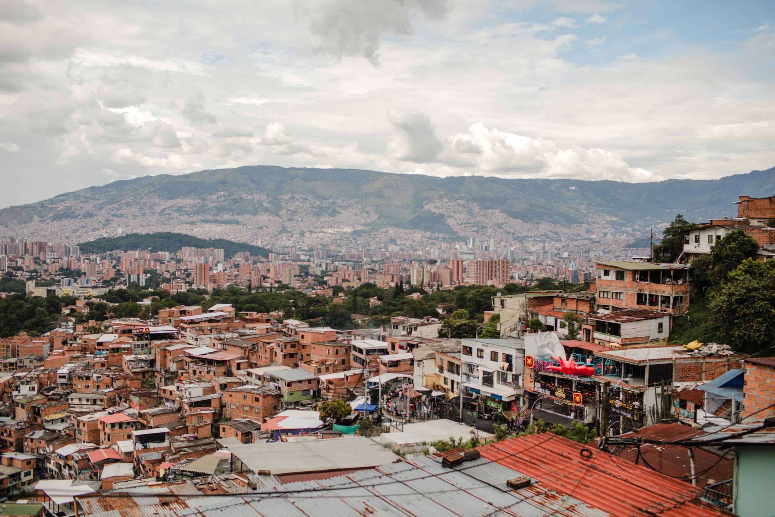 Stunning cityscape of Medellín with vibrant rooftops and distant mountains under a cloudy sky.